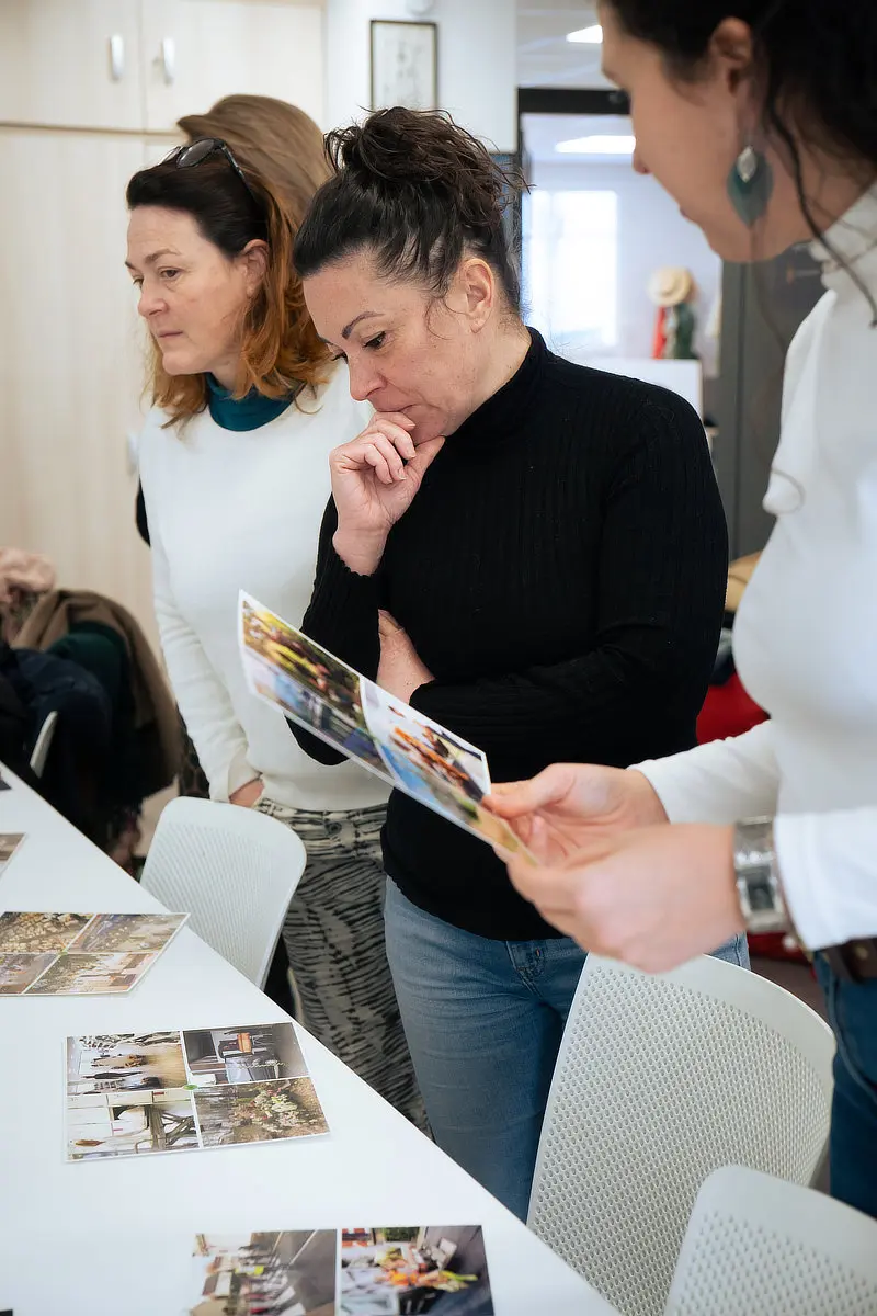 3 participantes explorent leur projet à l'aide de photos, lors d'un atelier de développement personnel et professionnel.