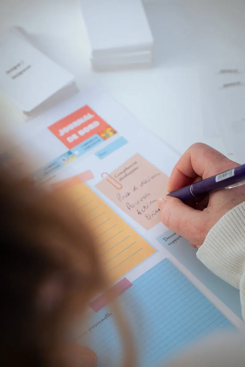Une participante fait son bilan écrit, lors d'un atelier pour concrétiser sa reconversion professionnelle.